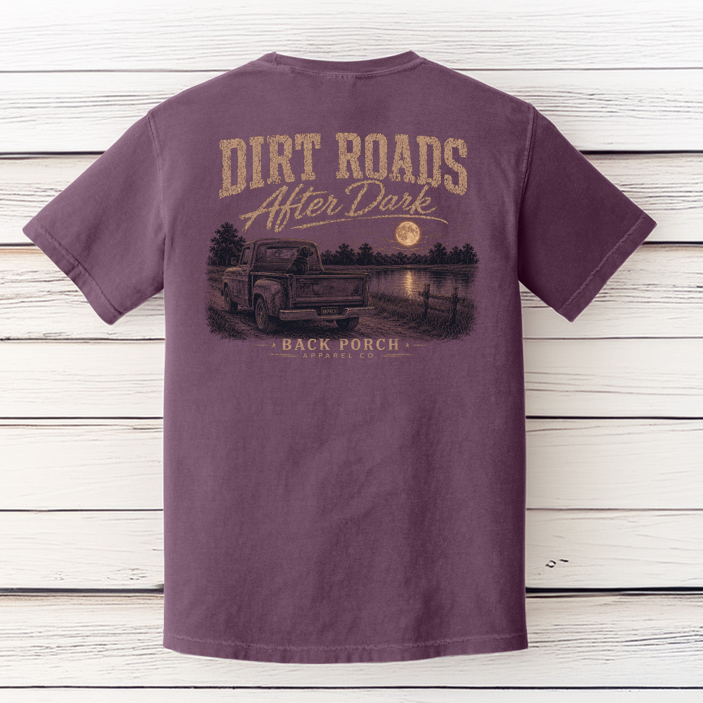 Back view of the Back Porch Apparel Dirt Roads After Dark Comfort Colors Berry t-shirt featuring a vintage pickup truck, black Labrador, full moon over a lake, and distressed country graphic.