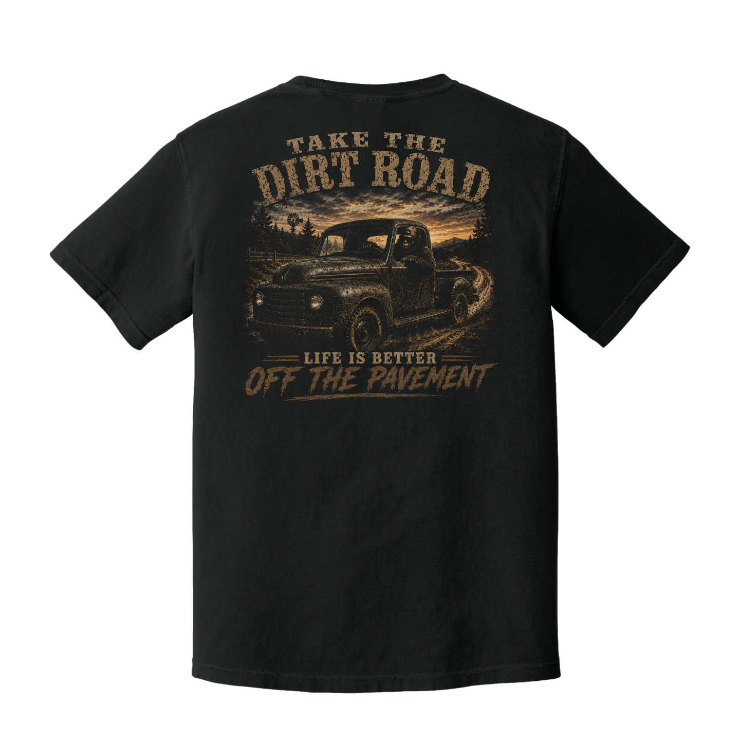 Back of Black Comfort Colors t-shirt featuring Bigfoot driving a vintage pickup truck with the words "Take the Dirt Road – Life Is Better Off the Pavement."