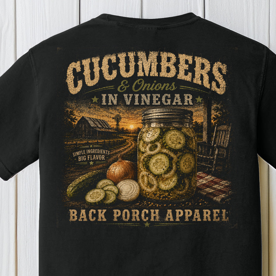 Distressed southern farmhouse graphic featuring cucumbers and onions in vinegar inside a mason jar with rustic porch scenery on a black Comfort Colors shirt.
