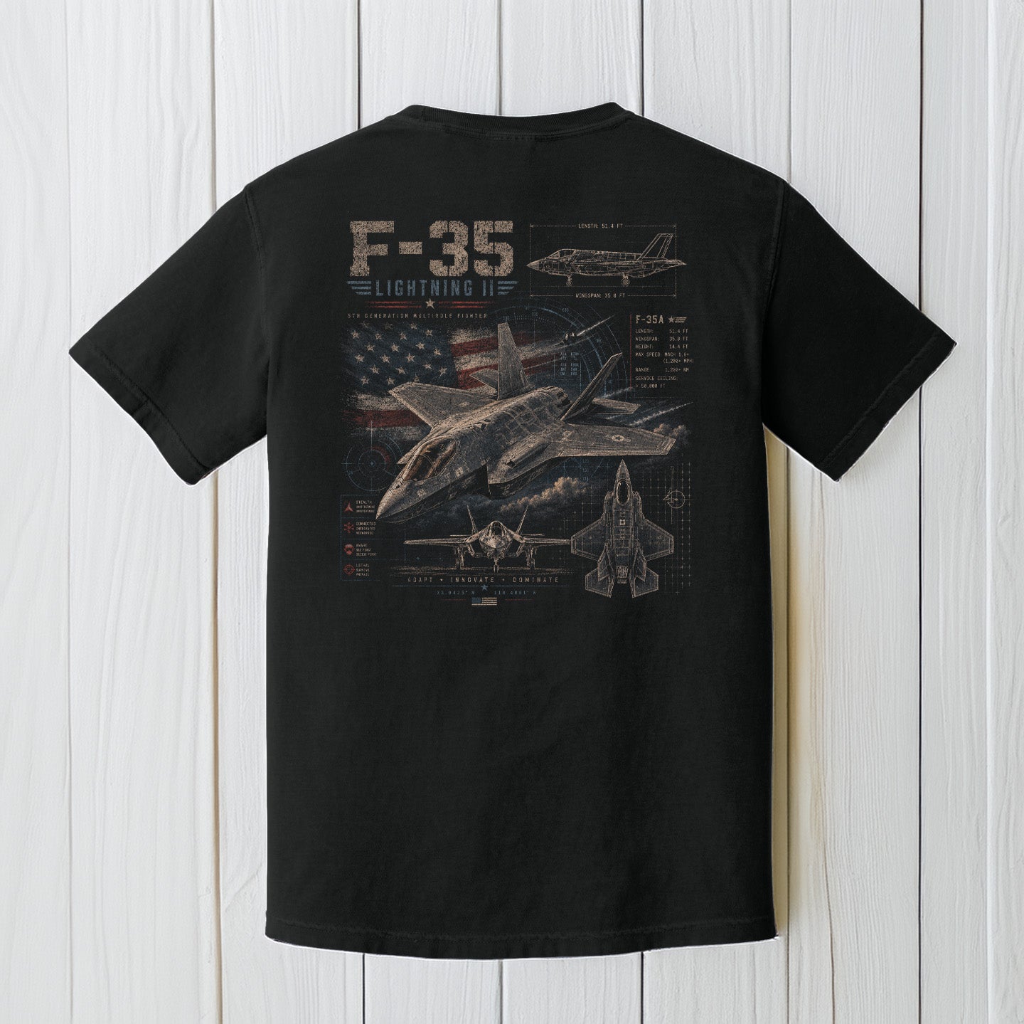 Black Comfort Colors F-35 fighter jet t-shirt displayed on a white wood background.