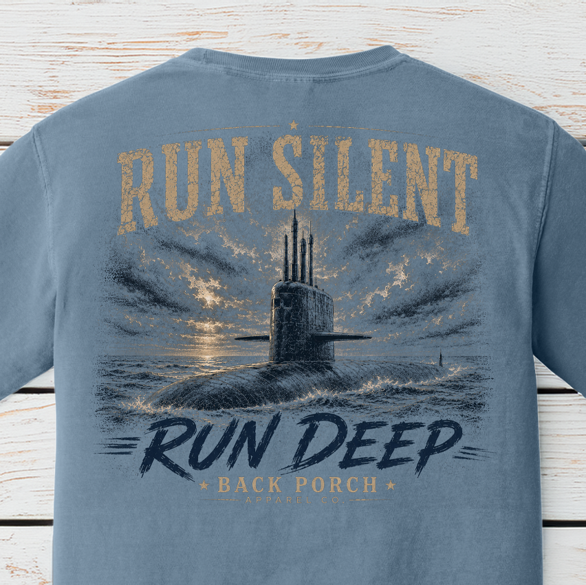 Close-up of the Run Silent Run Deep submarine artwork on a Blue Jean Comfort Colors t-shirt featuring a submarine beneath dramatic skies.