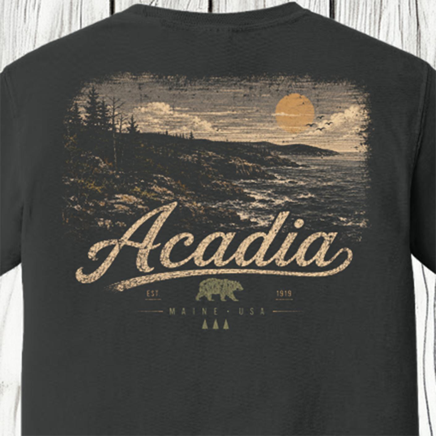Close-up of vintage Acadia National Park back graphic featuring Maine coastline, ocean waves, evergreen trees and sunset