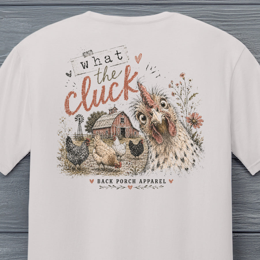 Close-up of the What the Cluck chicken graphic featuring a curious chicken, barn, flowers and vintage distressed artwork.
