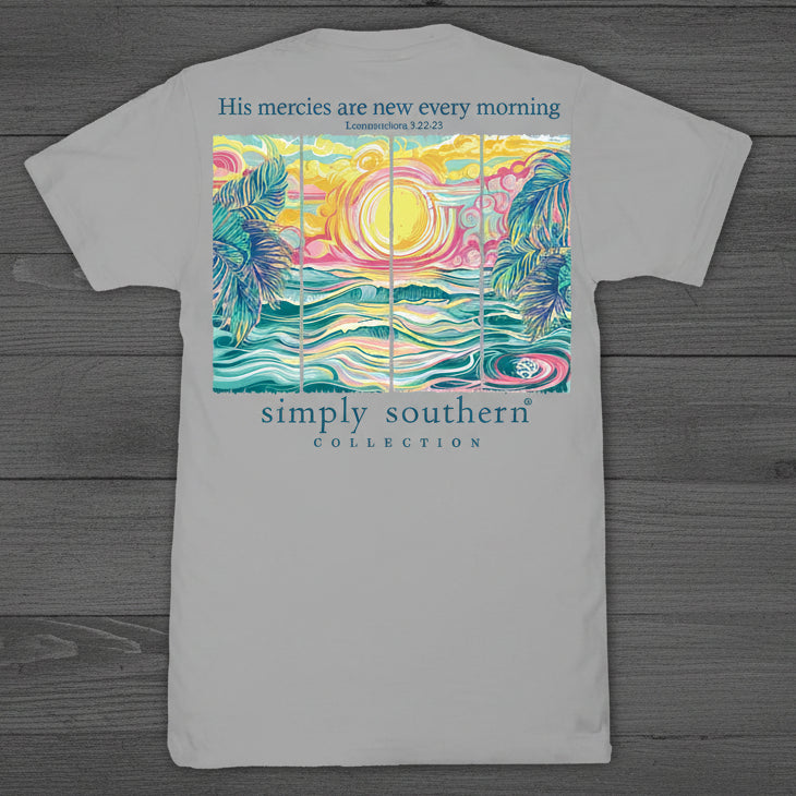 Simply Southern “His Mercies Are New Every Morning” short sleeve T-shirt featuring a colorful coastal sunrise with palm trees and ocean waves on a gray background
