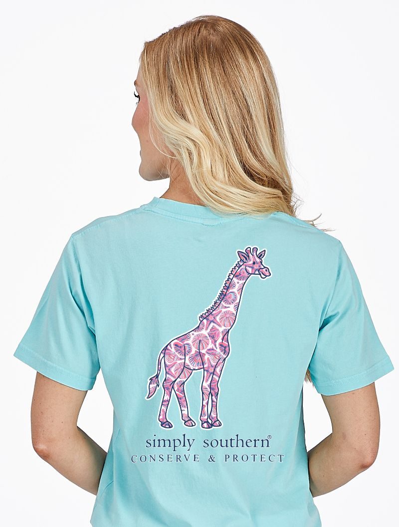 Model wearing Simply Southern aqua giraffe animal conservation T-shirt with wildlife design on back