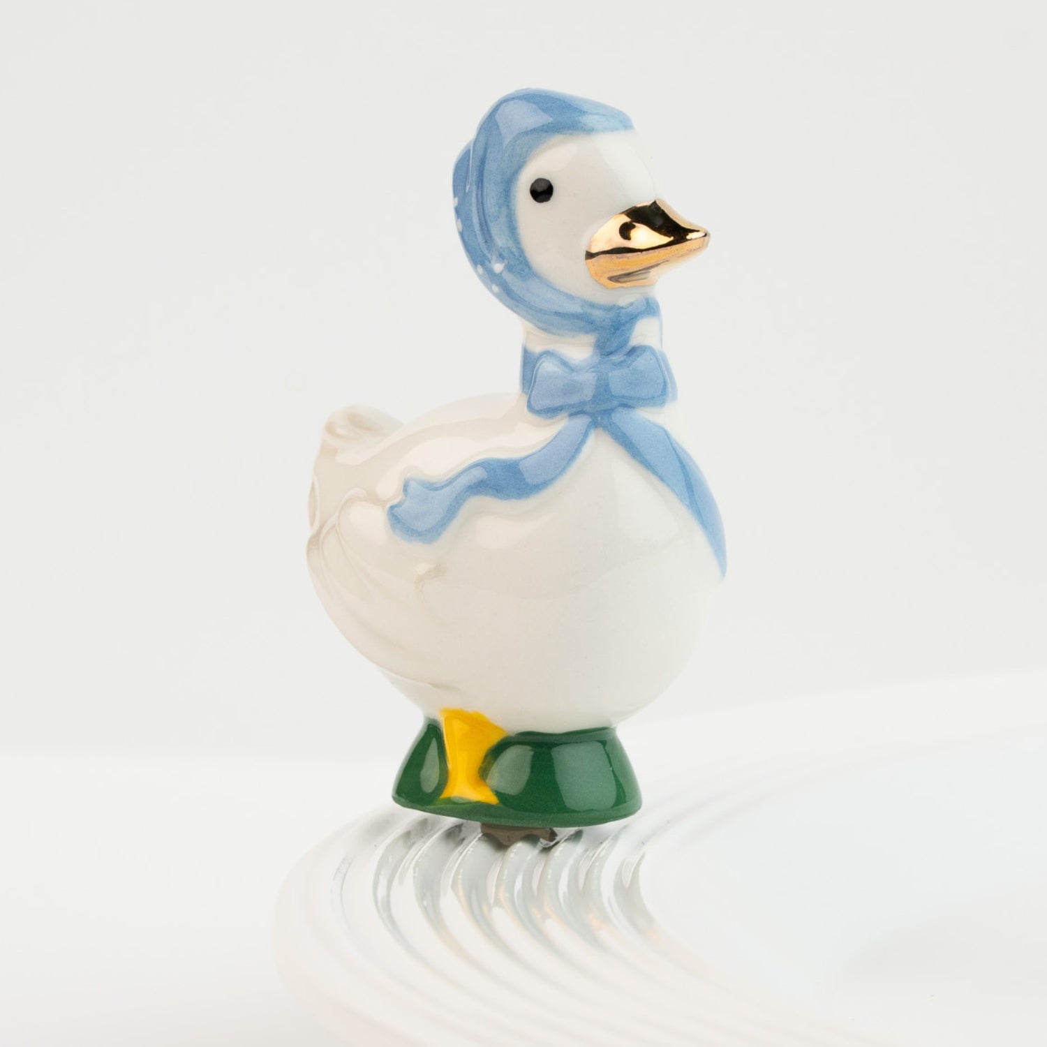 Nora Fleming Porch Pal goose mini wearing blue bonnet on Nora Fleming platter