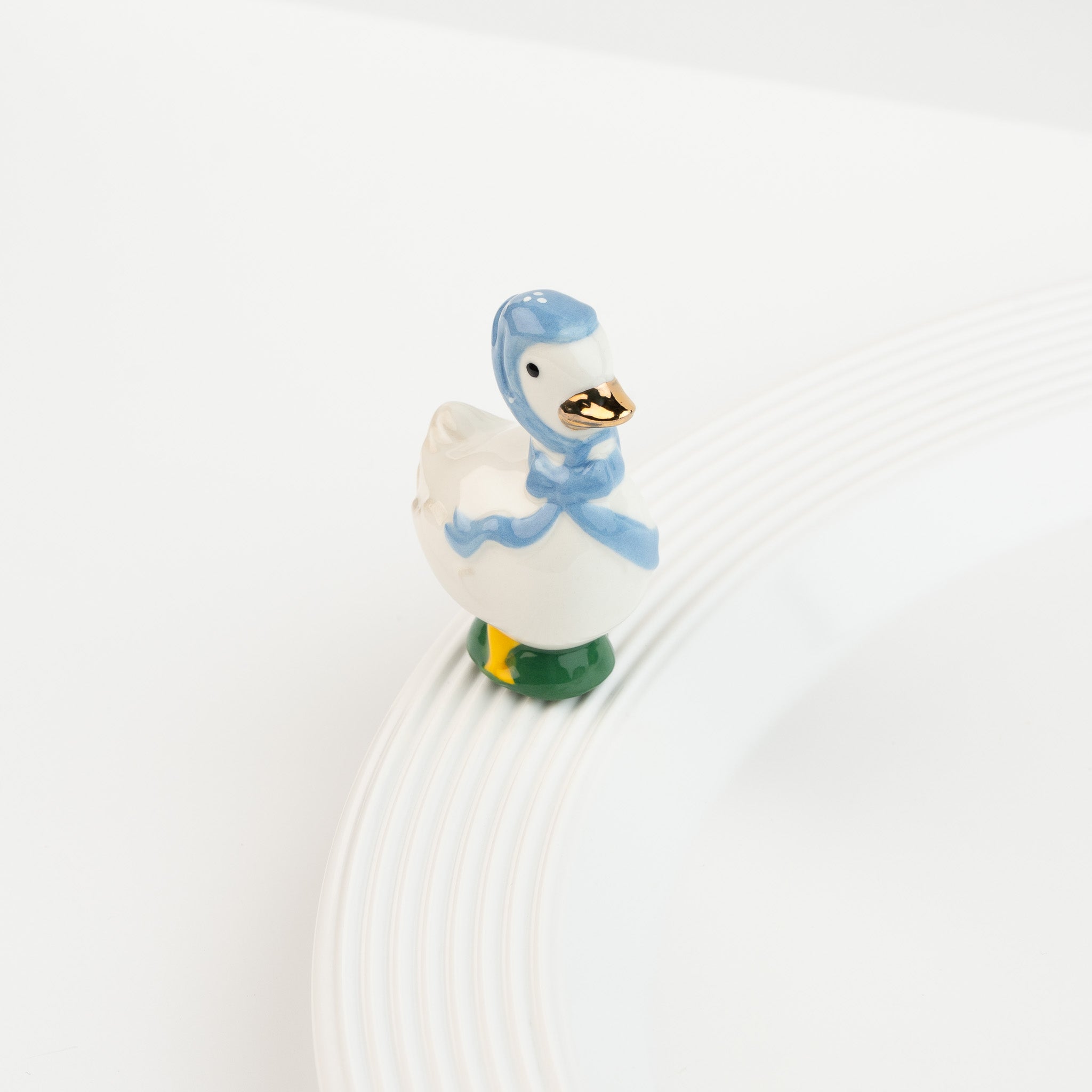 Nora Fleming Porch Pal goose mini wearing blue bonnet on Nora Fleming platter