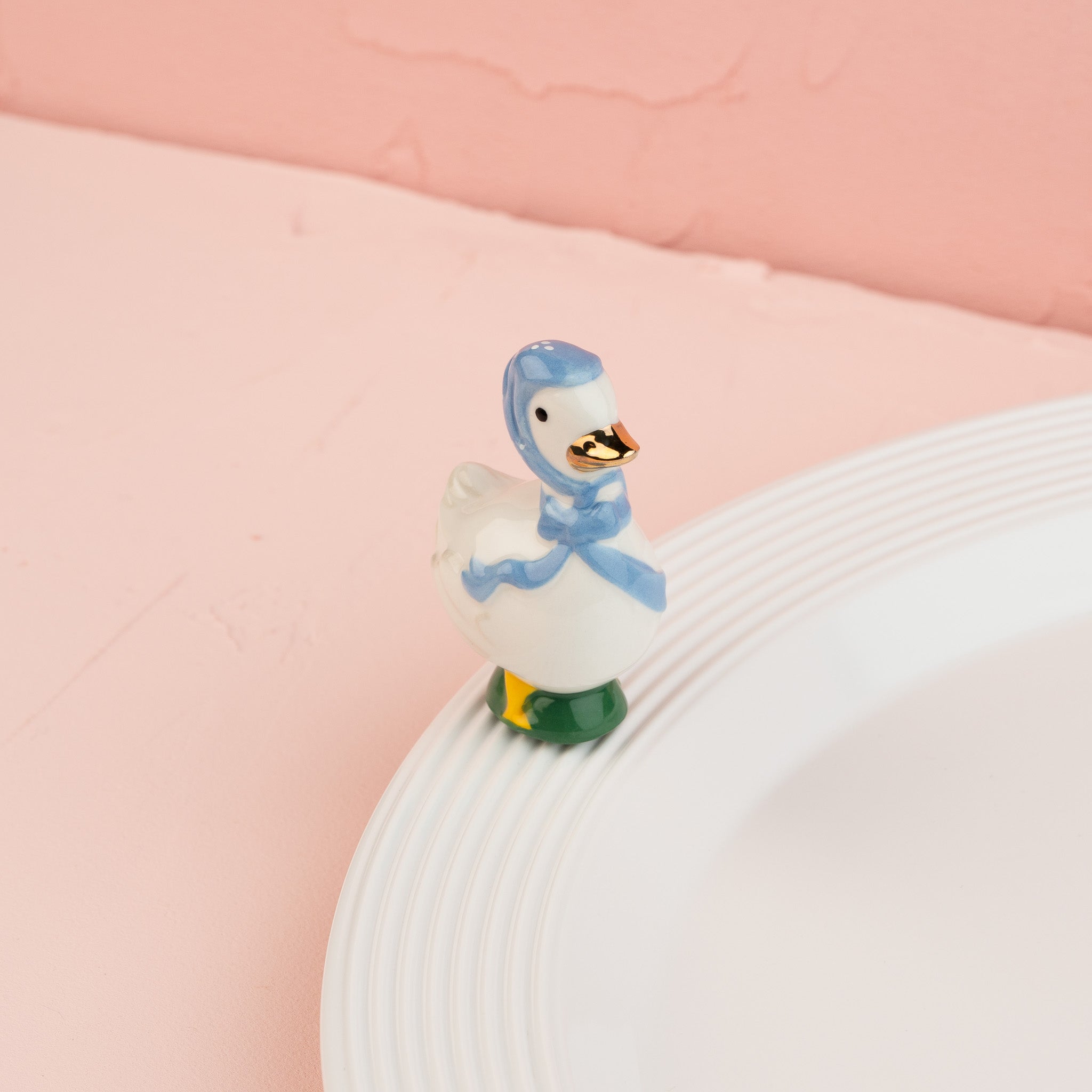 Nora Fleming Porch Pal goose mini wearing blue bonnet on Nora Fleming platter