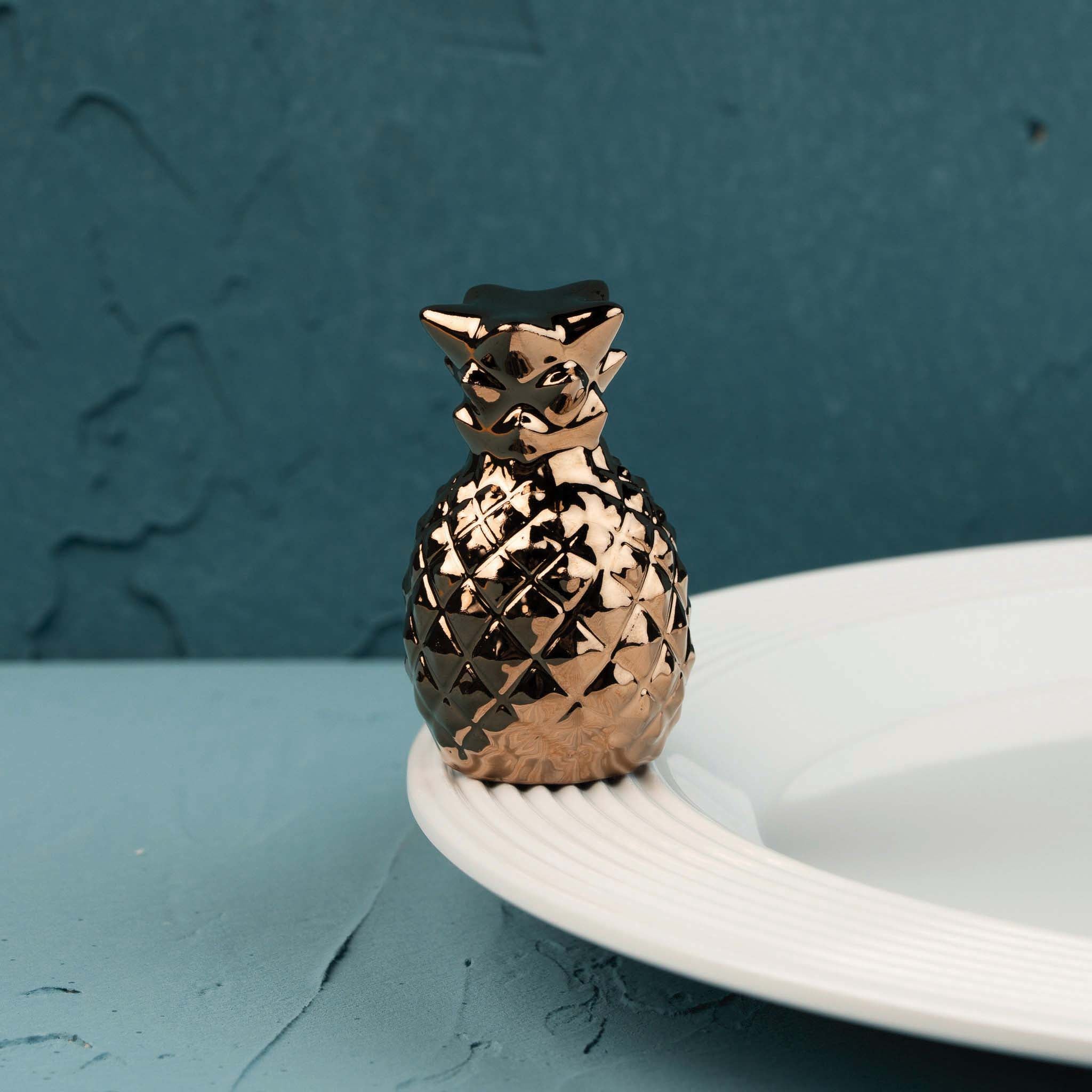 Nora Fleming Luxe Hospitality metallic bronze pineapple mini on a white Nora Fleming serving piece