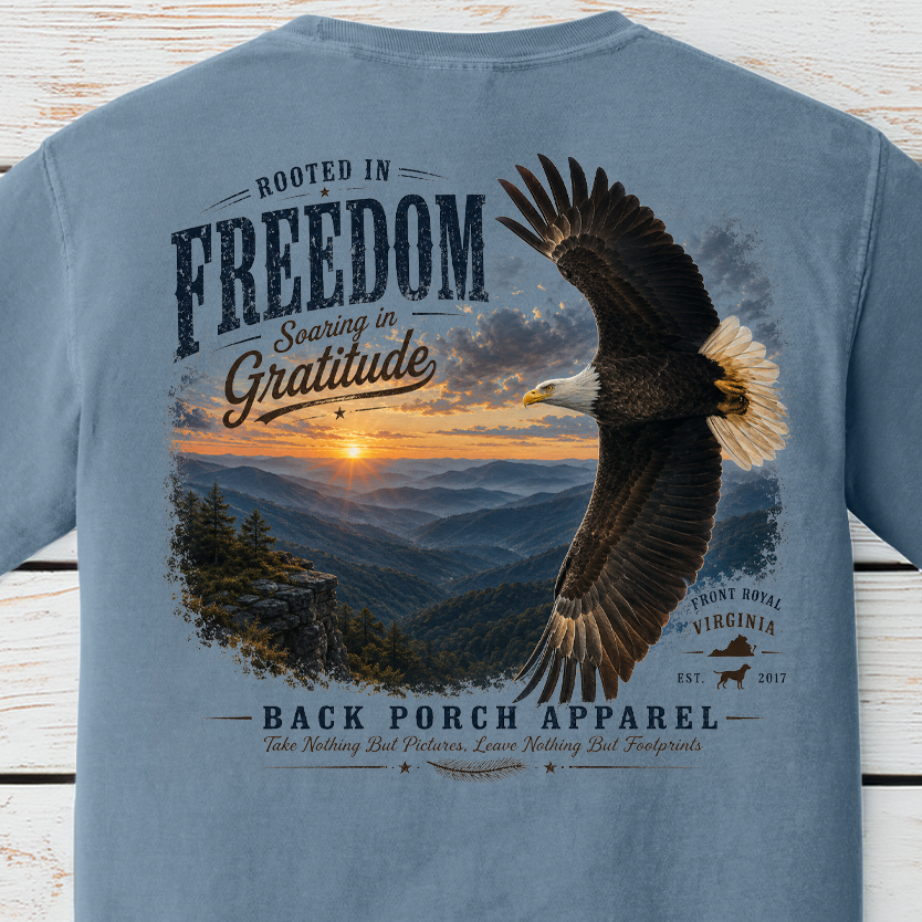 Patriotic bald eagle artwork flying over mountain scenery with Rooted In Freedom and Soaring In Gratitude message