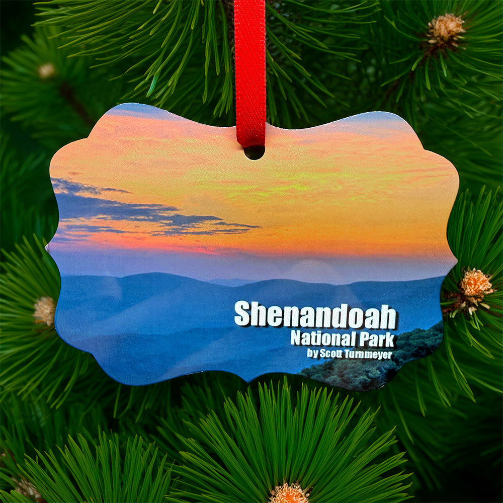 Shenandoah National Park sunset metal ornament with red ribbon, featuring colorful mountain sunset on front and park map with coordinates on back