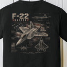 Detailed F-22 Raptor fighter jet blueprint graphic with distressed American flag artwork on a black Comfort Colors shirt.