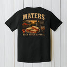 Black Comfort Colors t-shirt hanging on a wood background featuring a rustic southern tomato sandwich and porch life graphic design.