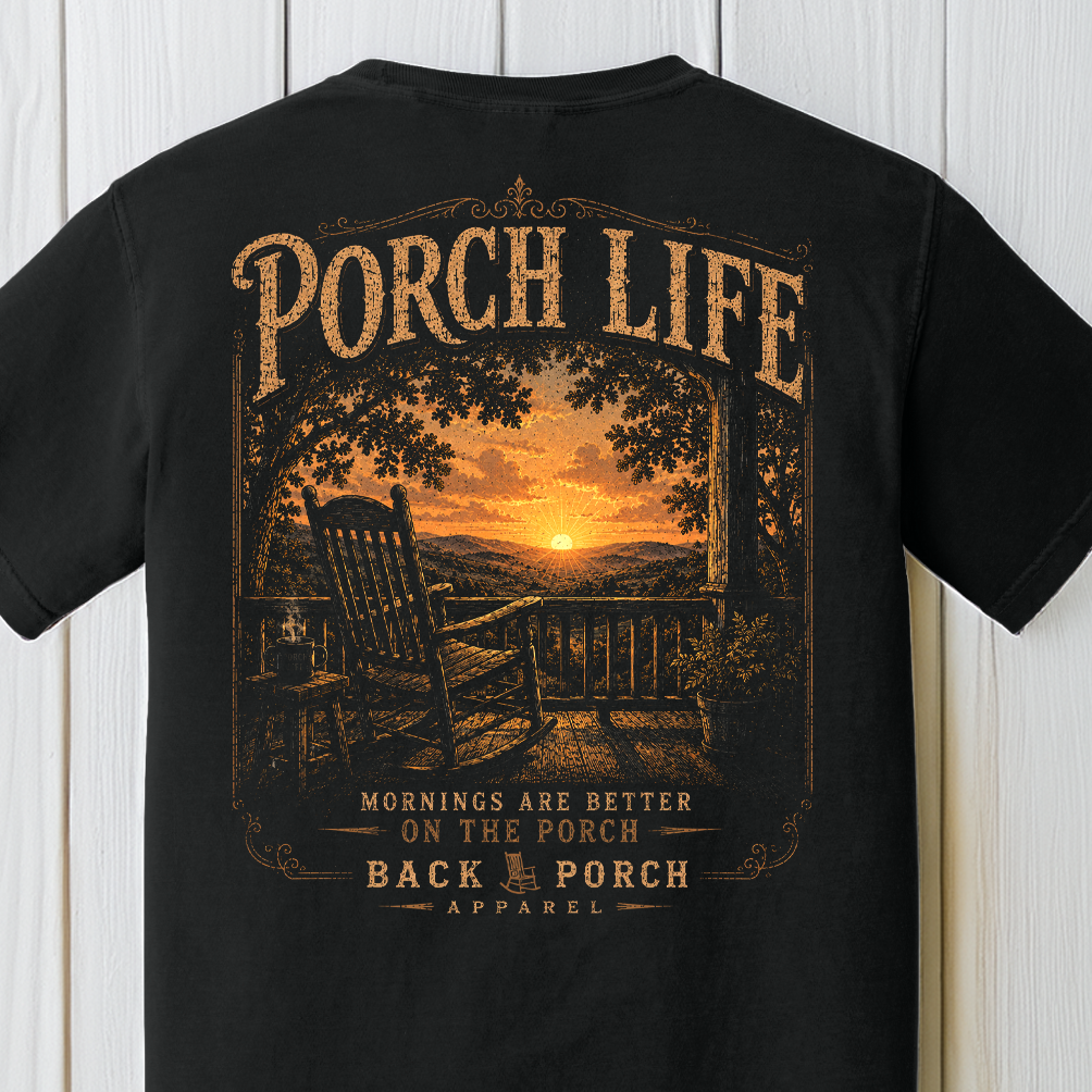 Close-up of the Porch Life Mornings Are Better on the Porch artwork showing a rocking chair, coffee cup, sunrise, and scenic country landscape on a Black Comfort Colors t-shirt.