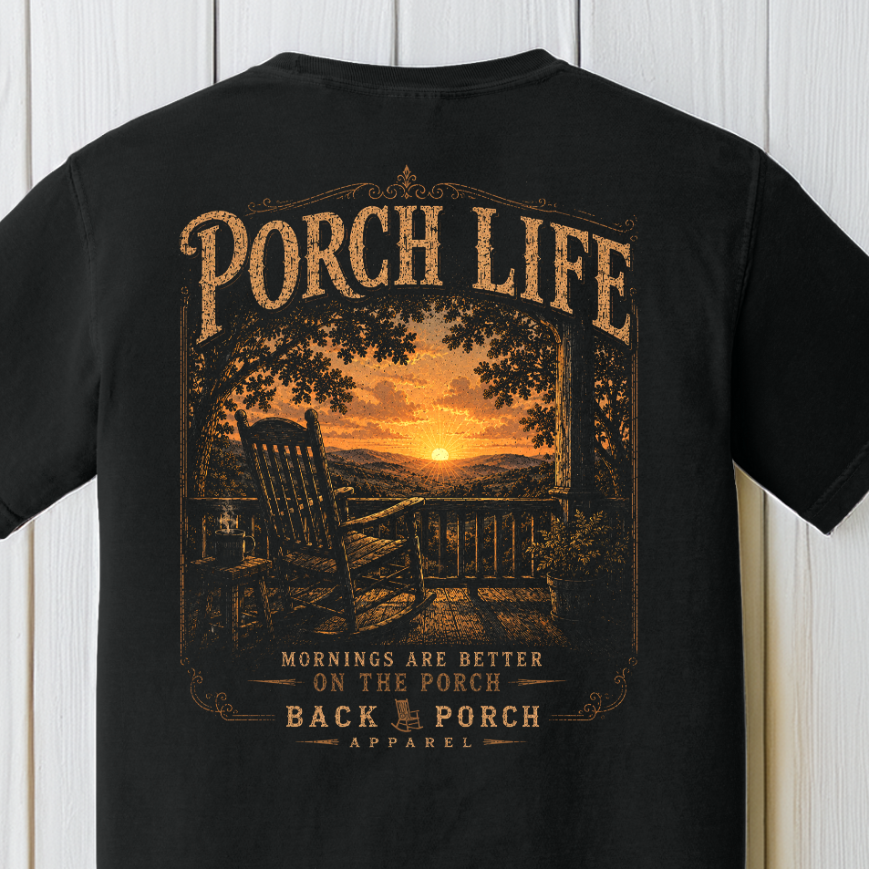 Close-up of the Porch Life Mornings Are Better on the Porch artwork showing a rocking chair, coffee cup, sunrise, and scenic country landscape on a Black Comfort Colors t-shirt.