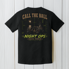 Black Comfort Colors aircraft carrier Night Ops t-shirt displayed on a white wood background featuring a nighttime carrier landing design.