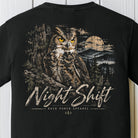 A black short-sleeve t-shirt featuring a large graphic print of a great horned owl in a forest at night under a full moon, with the text 'Night Shift' and 'BACK PORCH APPAREL' printed below.