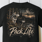 Black short-sleeve t-shirt with a large back graphic showing two wolves in a forest at sunset, with the text 'Pack Life' and 'BACK PORCH APPAREL' printed below.