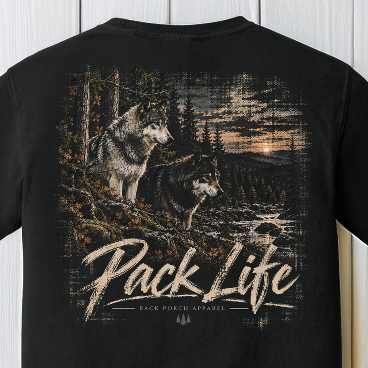 Black short-sleeve t-shirt with a large back graphic showing two wolves in a forest at sunset, with the text 'Pack Life' and 'BACK PORCH APPAREL' printed below.