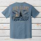 Blue Jean Comfort Colors submarine graphic t-shirt displayed on a white wood background featuring the Run Silent Run Deep design.
