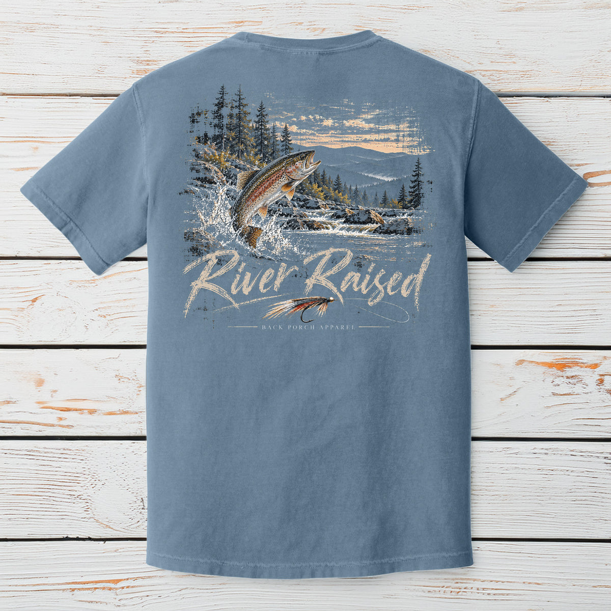 A blue short-sleeve t-shirt shown from the back, featuring a large graphic print of a jumping fish, mountains, trees, and the text 'River Raised' with 'Rise Fish Experts' underneath.