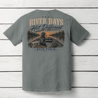 Back view of the Back Porch Apparel River Days Hit Different Comfort Colors Grey t-shirt featuring a Labrador sitting in a jon boat with fishing rods, cooler, and a sunset river scene.
