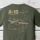 Distressed A-10 Thunderbolt II military aircraft blueprint graphic featuring detailed schematics and tactical aviation artwork on a Comfort Colors Moss shirt.