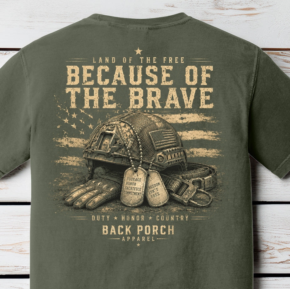 Distressed patriotic military graphic featuring a tactical combat helmet, dog tags, gloves, and American flag artwork on a Comfort Colors Moss shirt.