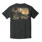 A dark charcoal gray short-sleeve t-shirt shown from the back, featuring a vintage-style graphic of a tropical Key West scene with palm trees, a lighthouse, a sailboat, and a sunset, with 'Key West' printed in large script.