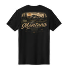 A black short-sleeve t-shirt with a vintage-style Montana graphic on the front, featuring a mountain landscape, a sunset, and the word 'Montana' in a cursive font.
