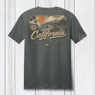 A dark gray crewneck t-shirt shown from the back, featuring a large vintage-style California graphic print with a sunset, palm trees, mountains, and the word 'California' in script.