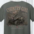 Distressed southern country girl graphic featuring a camouflage ATV, rustic woodland background, pink bow accents, and “Raised on Dirt & Grace” typography on a Comfort Colors shirt.