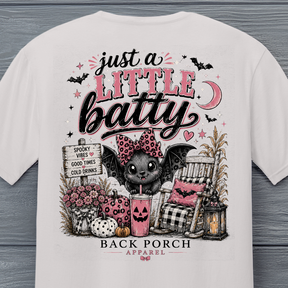 Close-up of Just a Little Batty Halloween shirt design with cute bat, pumpkins, pink flowers and fall porch scene