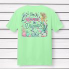 Back Porch Apparel I'm A Mermaid In Disguise short sleeve mint green t-shirt featuring a colorful mermaid, dolphins, seashells, coral, and ocean-themed back graphic.