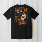 Back Porch Apparel Creepin' It Real black Comfort Colors T-Shirt with ghost sitting beside a campfire