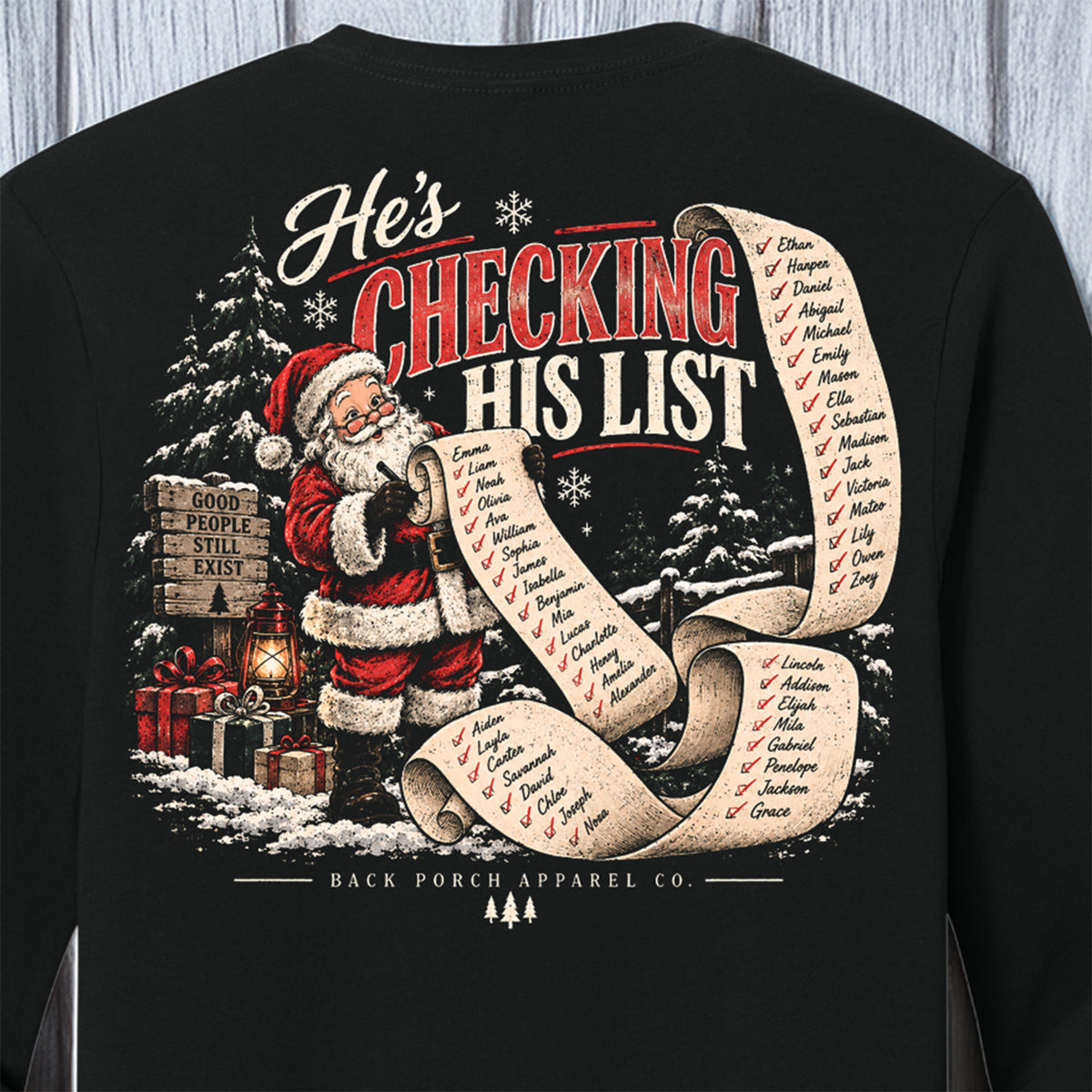 A black long-sleeve crewneck sweatshirt featuring a large Christmas-themed graphic on the back. The graphic shows Santa Claus holding a long scroll with a list of names under the text 'He's CHECKING HIS LIST' in red and white lettering.