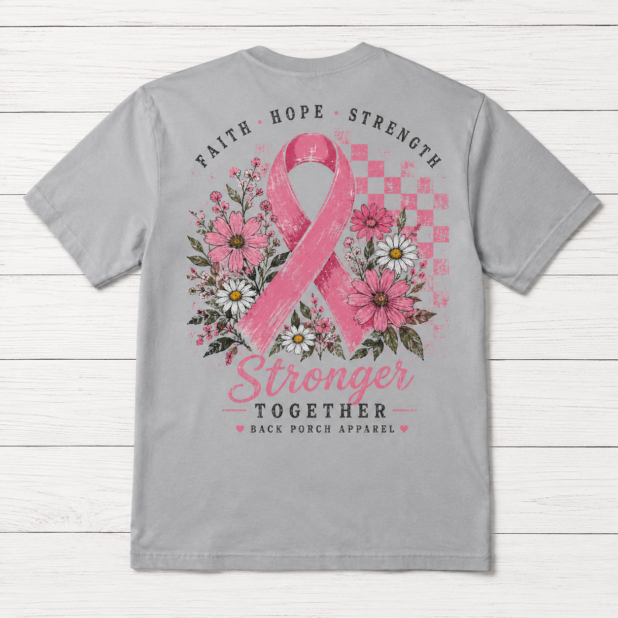 A light gray short-sleeve t-shirt shown from the back, featuring a large pink breast cancer awareness graphic with a pink ribbon, flowers, and the words 'FAITH HOPE STRENGTH' and 'Stronger TOGETHER' on a white wood plank background.