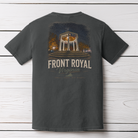 A dark charcoal gray t-shirt shown from the back, featuring a graphic print of the Front Royal Veterans Memorial Garden in Virginia. The graphic includes a night scene of the monument with warm lights and the text 'FRONT ROYAL Virginia' in a distressed cream font, laid flat on a white wood plank background.
