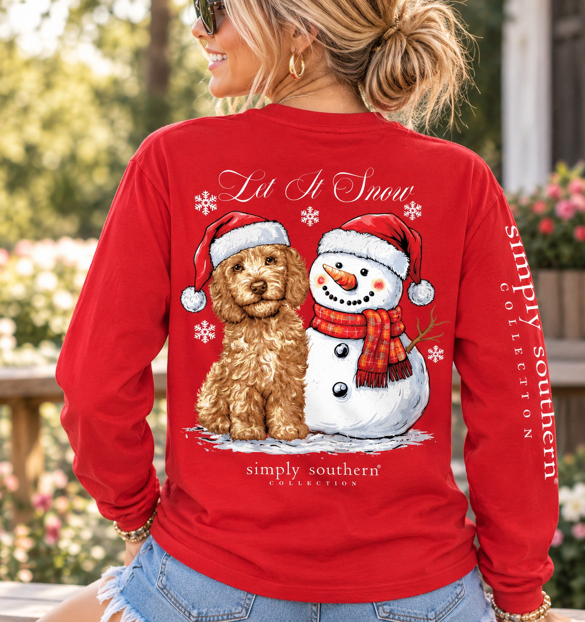 Woman modeling a red Simply Southern Let It Snow long sleeve shirt featuring a Christmas dog and snowman graphic on the back.