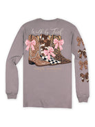 Back view of Simply Southern Driftwood long sleeve shirt with Walk by Faith lettering above three patterned western boots decorated with pink bows.