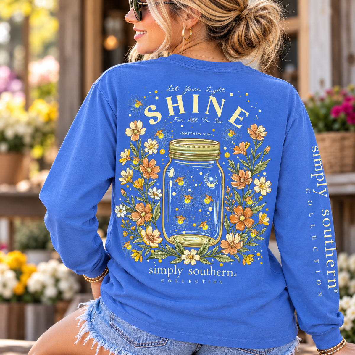 Woman wearing a Bali Blue Simply Southern Let Your Light Shine long sleeve shirt with firefly mason jar and floral back graphic.