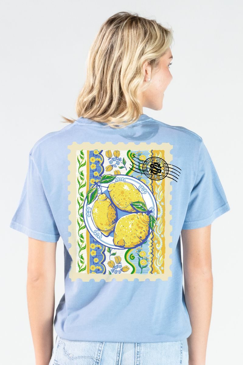 Model wearing a Simply Southern faded blue mineral washed t-shirt with lemon stamp design on the back