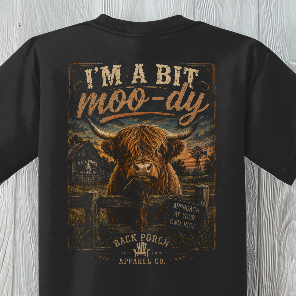 Close-up of the Youth Moody Highland Cow graphic featuring a shaggy Highland cow and vintage country artwork.