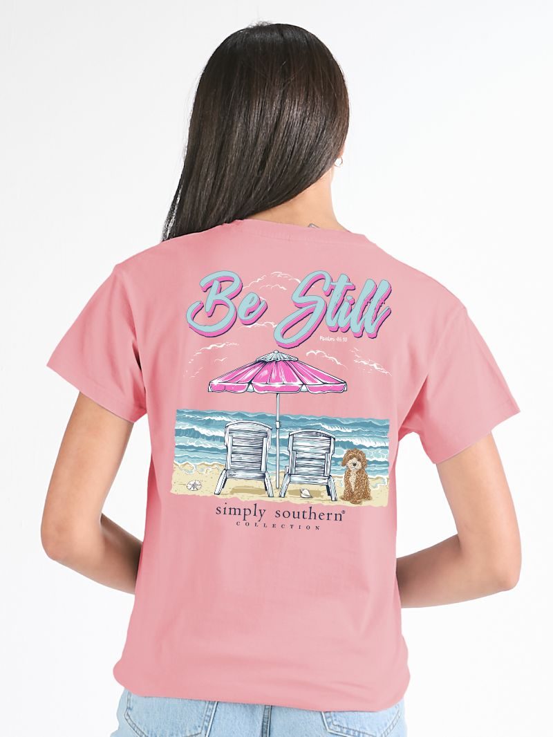 Simply Southern Be Still pink short sleeve cotton tee with beach chairs, umbrella, ocean waves, and dog graphic