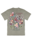 Back view of Simply Southern Let Kindness Bloom mineral washed graphic tee in Birch featuring colorful patchwork flowers, floral patterns, and the Let Kindness Bloom message.