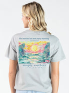 Simply Southern “His Mercies Are New Every Morning” short sleeve T-shirt featuring a colorful coastal sunrise with palm trees and ocean waves on a gray background