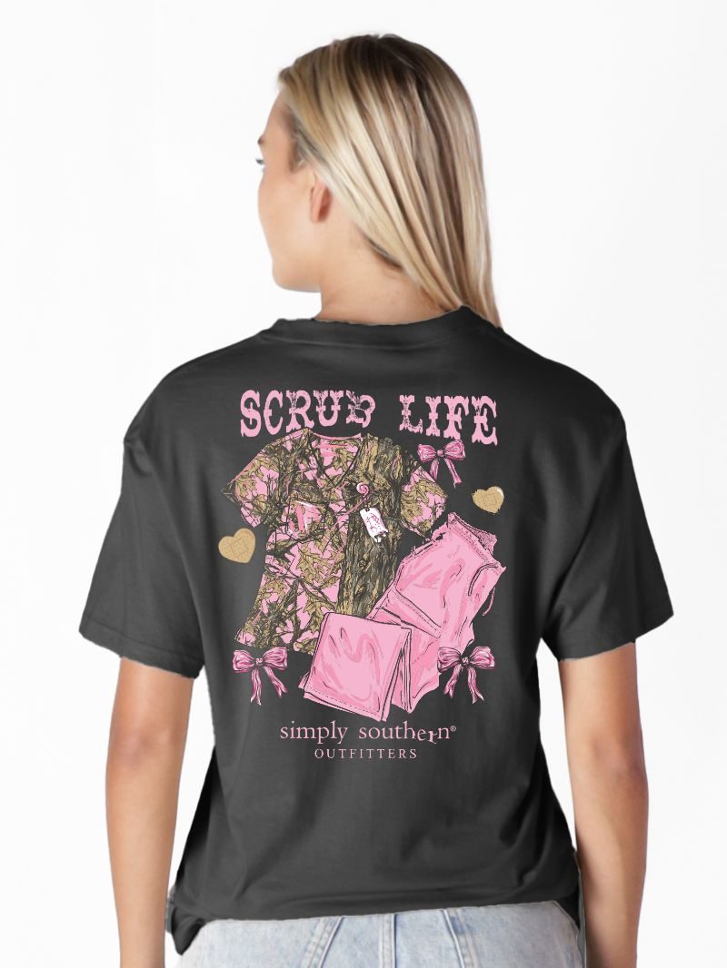 Model wearing Simply Southern black “Scrub Life” t-shirt with pink camo scrub graphic on back
