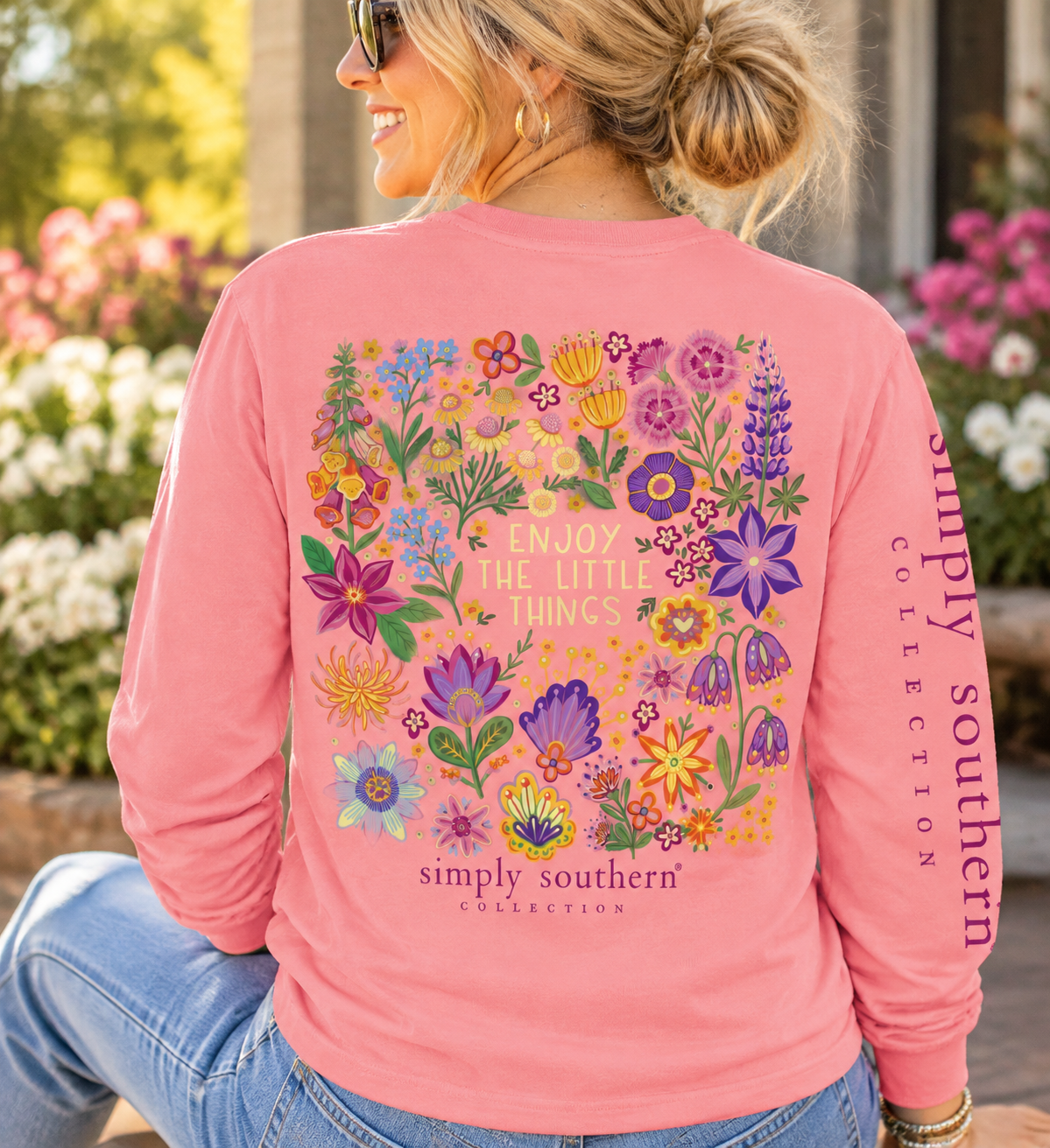 Woman wearing a Tea Rose Simply Southern long sleeve shirt with colorful wildflowers and Enjoy the Little Things graphic on the back.