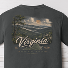 Close-up of the Virginia Blue Ridge Rooted graphic showing layered mountain ridges, sunset, mountain laurel, and the outline of Virginia on a Pepper Comfort Colors t-shirt.