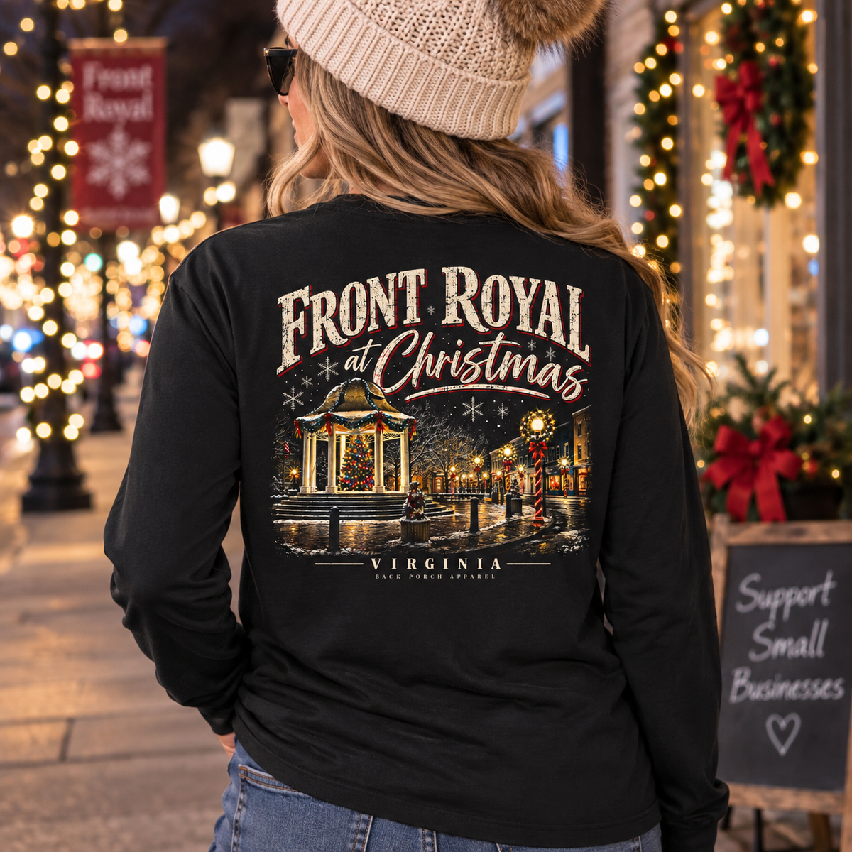 Woman wearing Front Royal at Christmas Comfort Colors black long sleeve shirt on a decorated small-town Main Street at Christmas